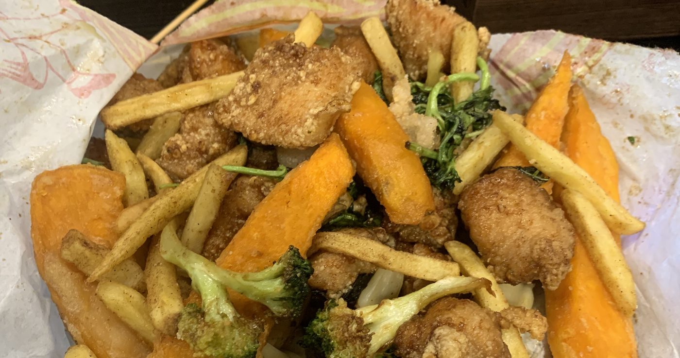 一袋鹹酥雞：炸雞塊、薯條、炸地瓜和花椰菜一起裝在紙袋裡