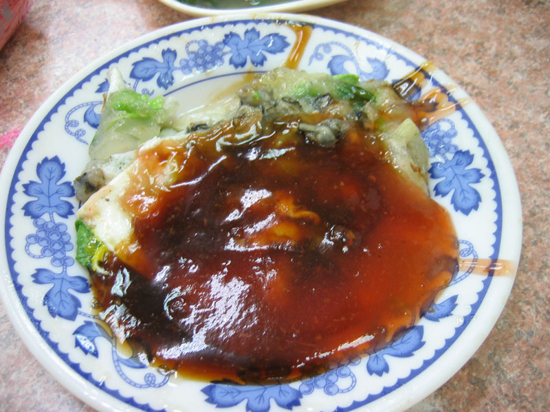 一份蚵仔煎，配蛋、地瓜粉漿與甜辣醬
